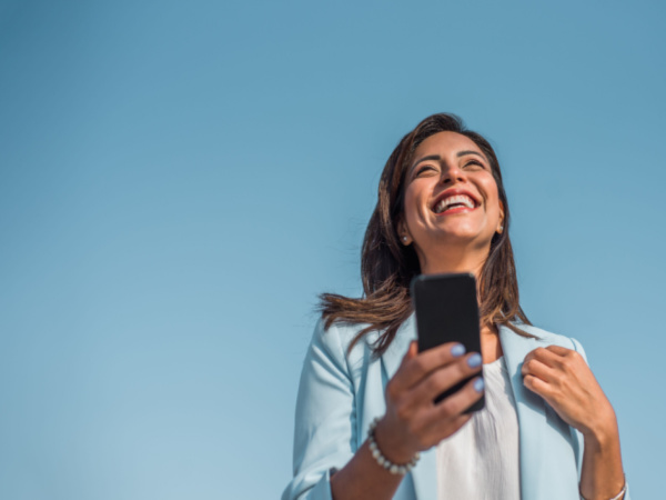 smiling woman looking up with phone