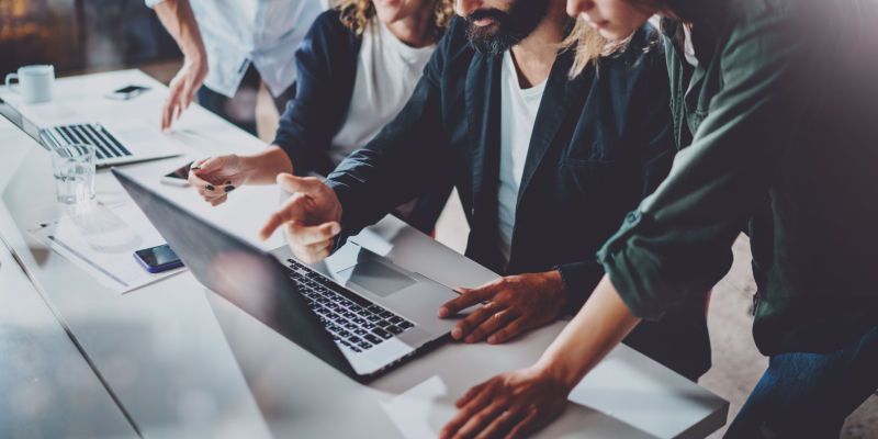 a group of people working on a laptop