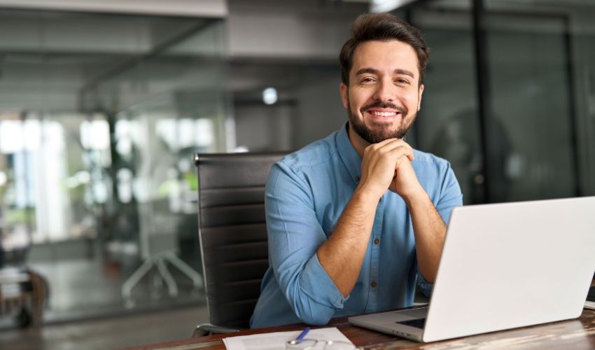 Smiling businessman working on laptop computer