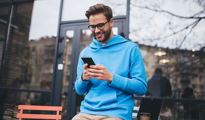happy guy using phone outdoor