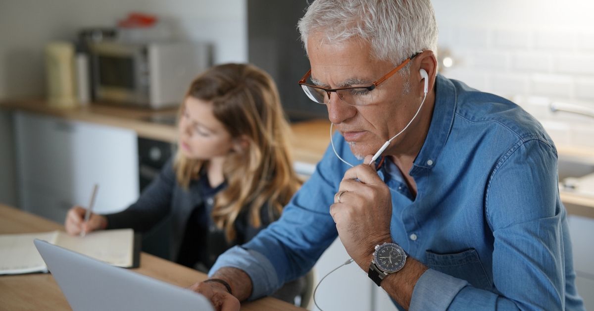 Work from home contact center agent tries to connect remotely as child does school work near by.