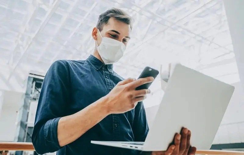 a man wearing a mask and looking at a phone
