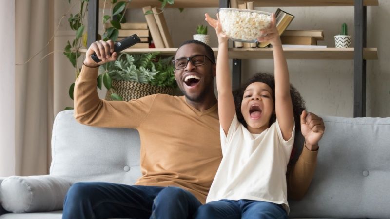 Happy father with kid daughter sport fans watching tv game