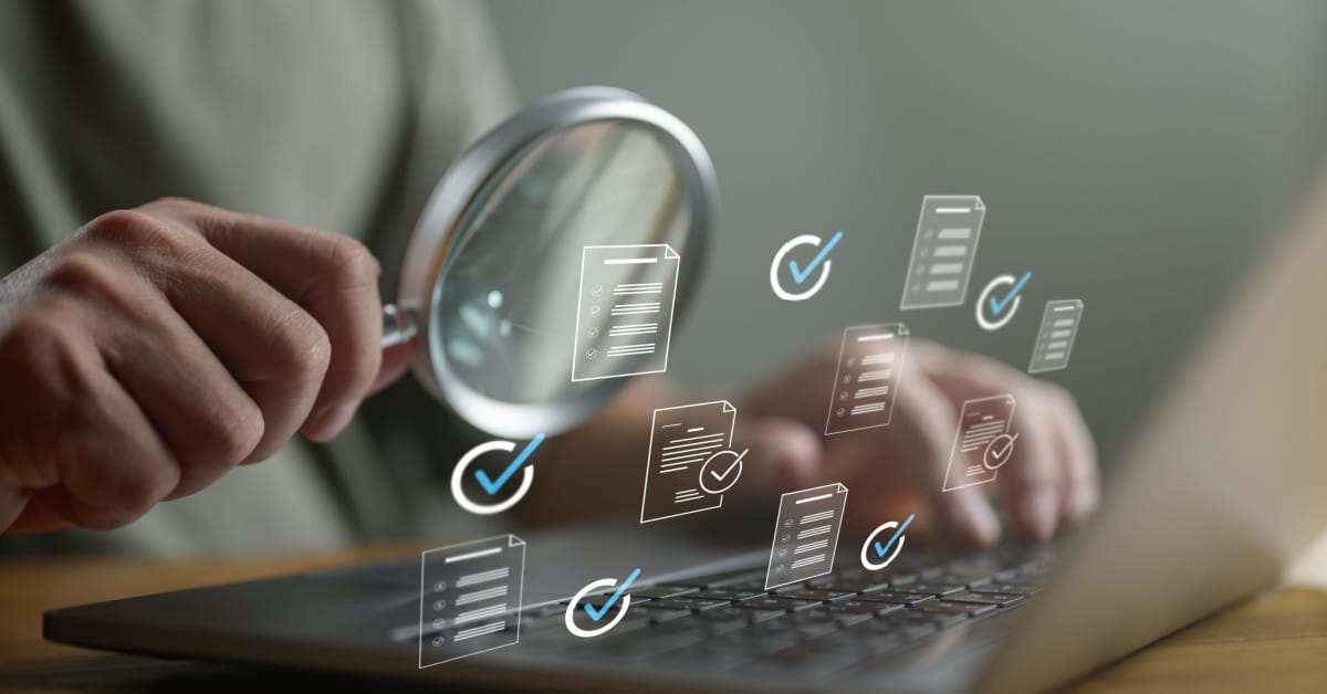 Quality analyst checking document on a laptop.
